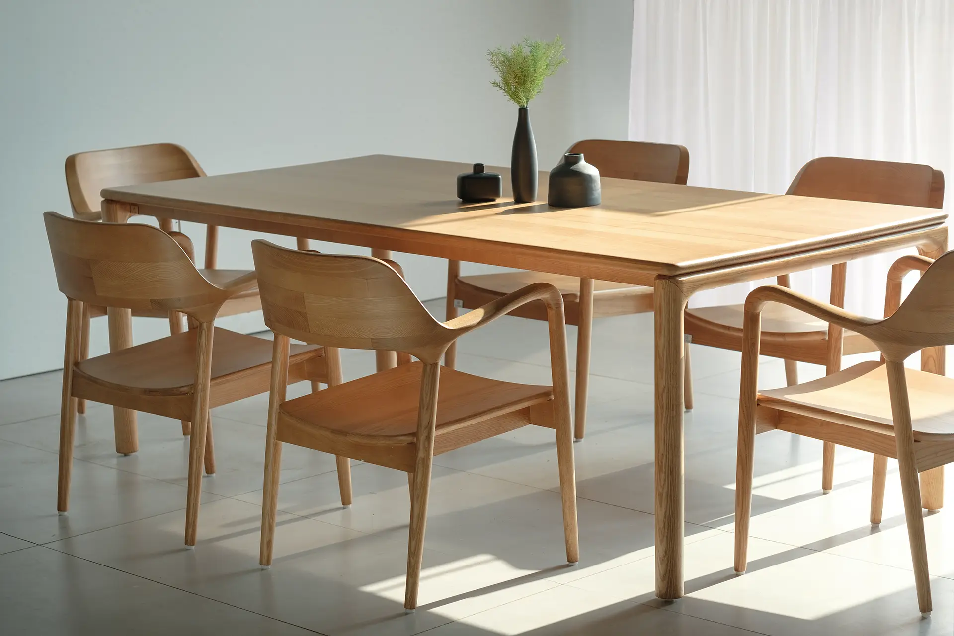 Warmly lit wooden dining table and chairs in a JOSECO Furniture setting
